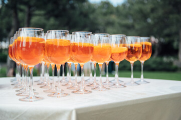 A lot of glasses with apple and orange juice on the buffet table