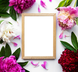 Wooden frame surrounded by beautiful pink peonies on a white background