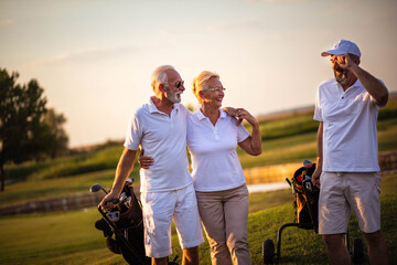 Three seniors golfers having fun on golf field. - 435032610