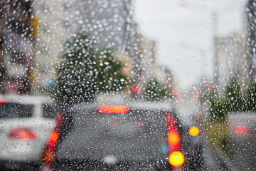 車のフロントガラスから見た雨の日の通勤の車の列の風景