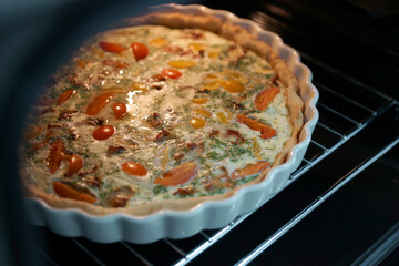 Quiche lauren in the oven in a baking dish