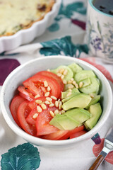 Vegetable salad with tomatoes, cucumbers, avocado and pine nuts