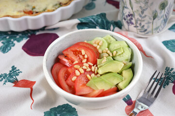 Vegetable salad with tomatoes, cucumbers, avocado and pine nuts