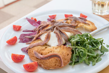 Burrata with anchovies, rocket and tomatoes