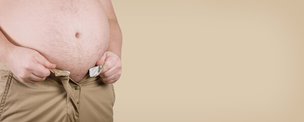 overweight corpulent man with fat belly unable to close his pants - obesity and adiposity concept