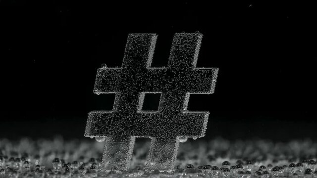 Hash tag sign underwater in bubbles of oxygen on black background.