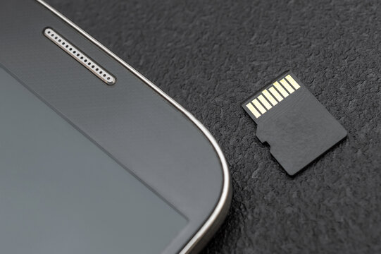 Micro SD memory card with smartphone. Close up.