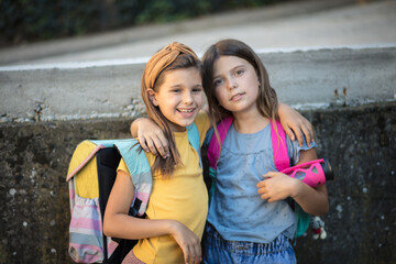 Two little school girl outside.