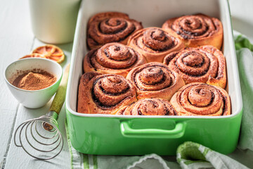 Hot cinnamon rolls with cocoa and sugar. Christmas snack.