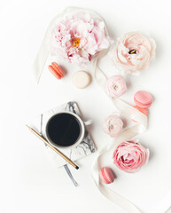 top view of cup of coffee and peony flowers on white background
