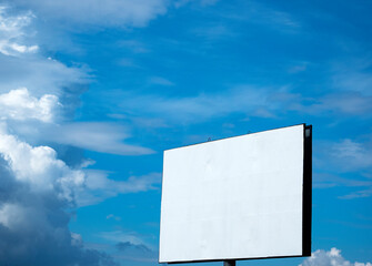 Empty billboard against blue sky with clouds