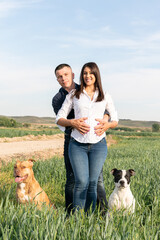 family portrait with two dogs and pregnant girl