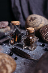 Glass bottles are filled with magical ingredients. Witch's table, stones.