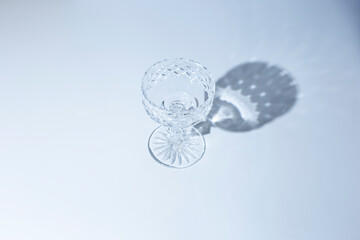 Fototapeta na wymiar empty glass goblet on a blue background. Top view, flat lay