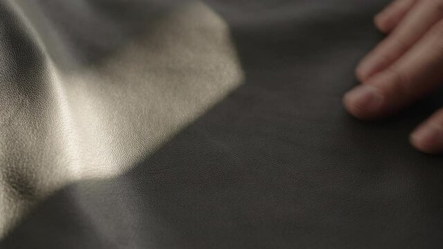 Man hand touching soft leather with sun shining from a window