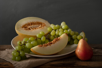 Classic composition with melon, grape and pear. Still life.