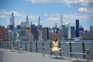 young woman relaxing on Williamsburg's waterfront in Brooklyn - obrazy, fototapety, plakaty