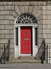 Typical Dublin door painted in red with arch decoration and letterbox 