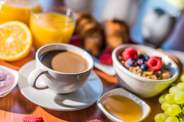 Fototapeta na wymiar Breakfast served with coffee, orange juice, croissants, cereals