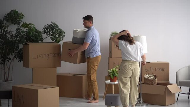 Married couple takes out the packed things from the apartment. Moving to a new home, minimalism and decluttering concept