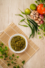 Top View of Sambal Lado Mudo or sambal Cabe Ijo. sambal cabe ijo is Traditional green chili paste from Padang, West Sumatra plated on plate and chili ingredient
