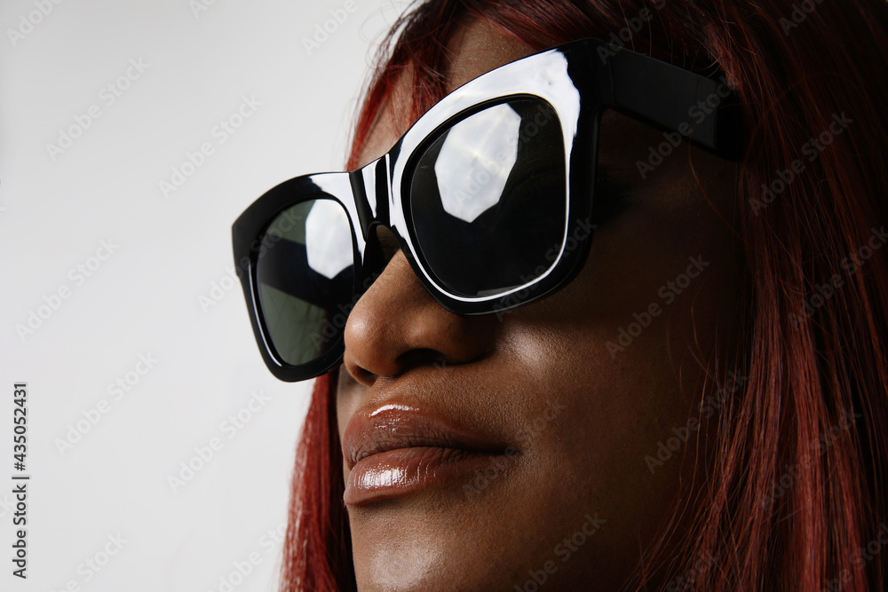 Wall mural beautiful black skin young woman wears sunglasses posing at studio. isolated.