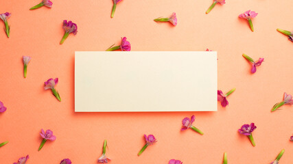Naklejka na ściany i meble Memo pad with pink flower pattern on orange background. flat lay, top view, copy space