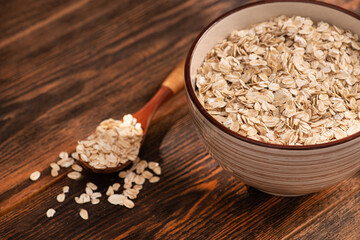 Bowl with oatmeal flakes on a wooden background