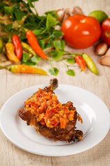 Ayam Geprek or Ayam sambal bawang. 

Ayam Geprek or Ayam Sambal Bawang is Popular fried chicken dish from Medan, deep-fried whole chicken and topped with sambal bawang