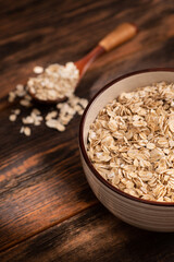 Bowl with oatmeal flakes on a wooden background