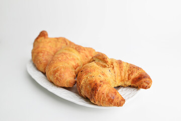 The fresh and crisp croissant on white plate isolated on white background. Delicious breakfast.