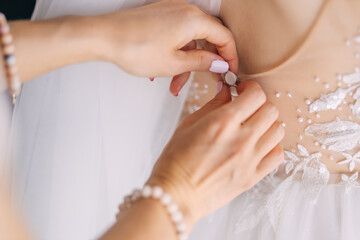 bridesmaid prepares the bride for the wedding day. The bride hel