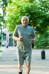 Elderly man during his jogging workout in a city park