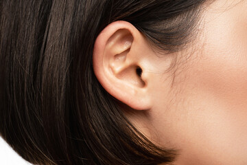 Closeup view of female ear - obrazy, fototapety, plakaty