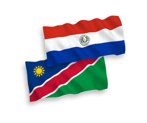 National vector fabric wave flags of Republic of Namibia and Paraguay isolated on white background. 1 to 2 proportion.