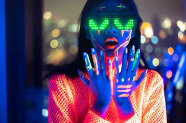 Neon  asian woman dancing. Fashion model woman in neon light, portrait of beautiful model with fluorescent make-up, Art and future design of female disco dancer posing in UV, colorful make up. - obrazy, fototapety, plakaty
