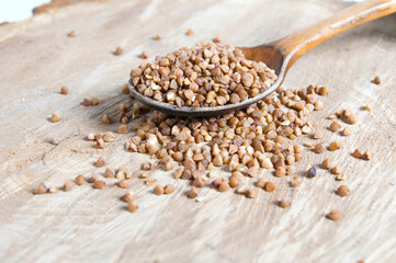 buckwheat in a wooden spoon on a vintage wooden background