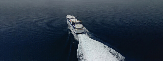 Aerial drone ultra wide photo of high speed passenger ferry cruising in high speed in Aegean deep...