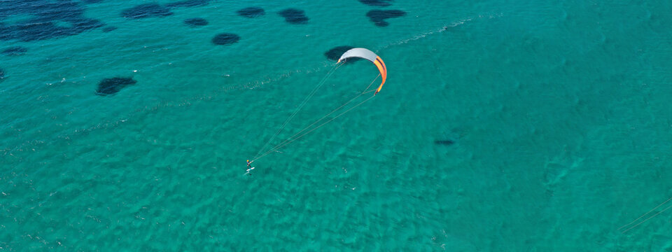 Aerial drone ultra wide photo of kite surfer practise in tropical exotic island bay with emerald crystal clear sea