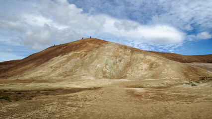 Walking up the volcanic mountain hill in Hverir and Namaskard geothermal area, Iceland, Europe
