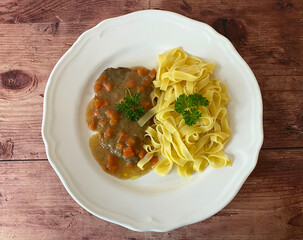 Austrian beef schnitzel with mustard in carrot, tomato paste, sour cream gravy. Served with Tagliatelle.