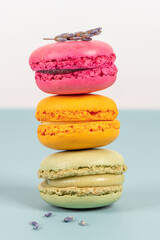 Cake macaron or macaroon on turquoise background from above, colorful almond cookies, pastel colors, vintage card