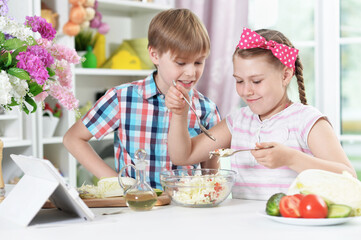 Cute brother and sister cooking together in kitchen