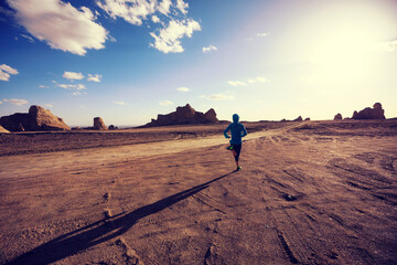 Fitness woman trail runner cross country running on sand desert
