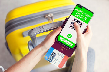 Health passport of vaccination, passport, tickets and luggage. Traveling during covid-19 pandemic.