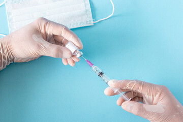 A close up of the vaccine and the syringe in the doctor's hand