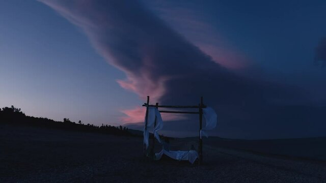 Baldacchino con letto in spiaggia prima dell'alba