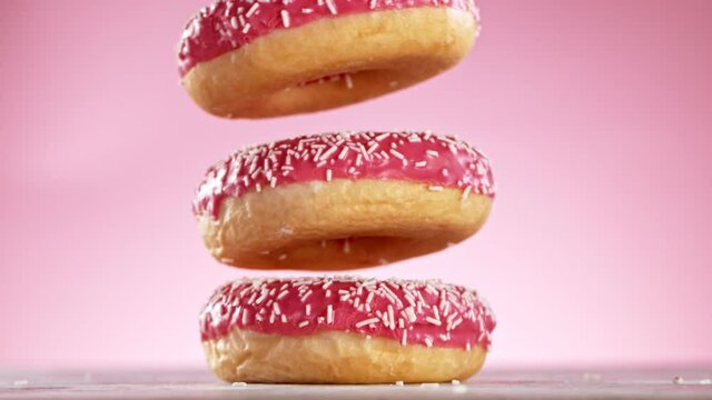 Delicious donuts falls on pastel background. Super Slow motion at 1000 fps