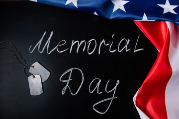 USA Memorial Day concept. American flag and dog tags on black background. Handwritten lettering on chalkboard.