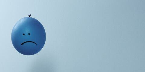 Blue balloon with sad face drawn. Unhappy emotions banner with copy space. Blue monday.